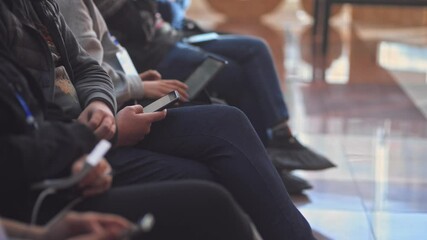business people using mobile phone during business seminar in auditorium irrl. listeners are sitting in the audience hall and looking at devices. addicted people browsing internet. typing on laptop
