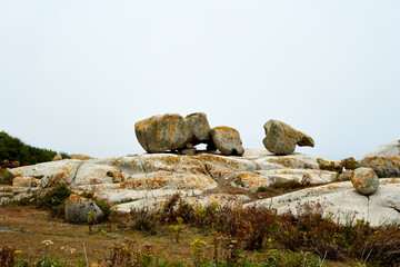 stacked stones landscape with cloudy sky and orange vegetation