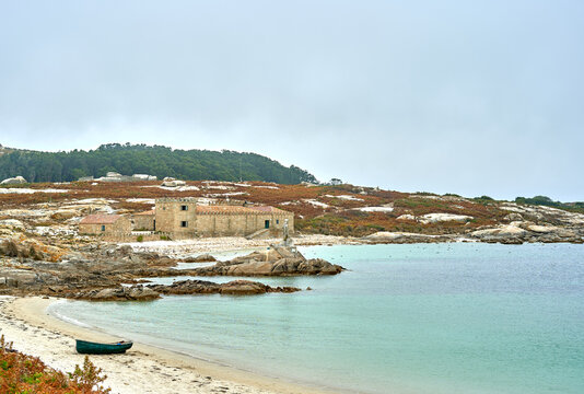 landscape with castle, blue sea and beach with stranded boat