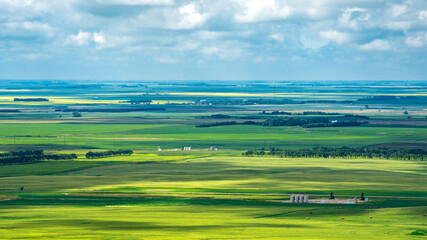 Obraz premium Aerial views Prairie landscapes of yellow and green fields under bold cloudy skies bright lighted areas