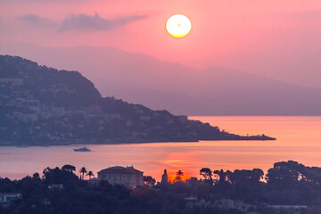 Fototapeta premium Lever de soleil flamboyant sur la baie des fourmis, la baie de Villefranche sur Mer et la presqu'île du Cap Ferrat