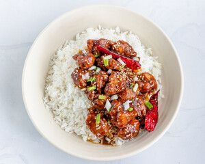 General Tso's chicken on Top of Rice in a Bowl Garnished with Sesame Seeds and Scallion Top View Food Photography