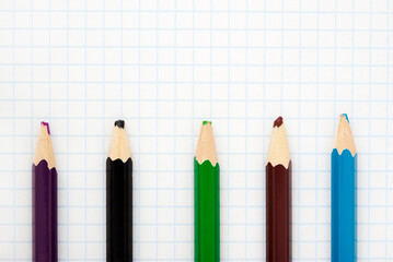 stupid group of colored pencils on notebook sheet