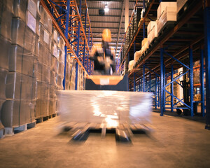 Storehouse area, Shipment. Speeding motion of warehouse worker unloading pallet goods in warehouse...