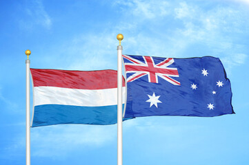 Fototapeta premium Netherlands and Australia two flags on flagpoles and blue sky