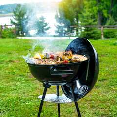 Barbecue time at the nature. BBQ grilling on the shore of a picturesque lake. Square photo.