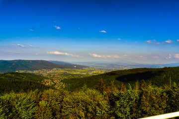 Naklejka na ściany i meble Bielsko Biala, South Poland: Wide angle from up above panoramic detailed high definition view of scenic mountains, green forest and city against blue sky