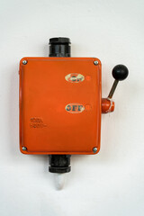 Orange colored vintage high voltage switch in a former factory