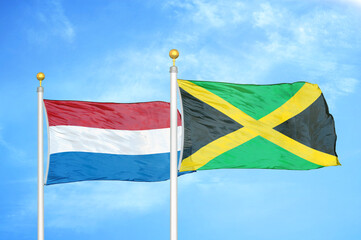 Netherlands and Jamaica two flags on flagpoles and blue sky