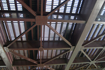 Looking up at the underside of a steel bridge.