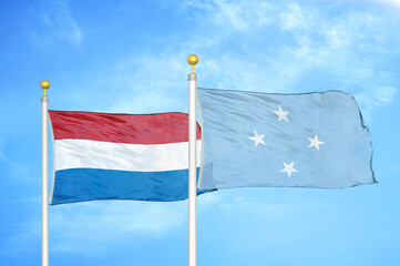 Netherlands and Micronesia two flags on flagpoles and blue sky