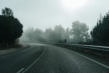 turning on a lonely road in a foggy mountain sunrise