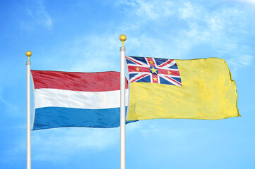 Netherlands and Niue two flags on flagpoles and blue sky