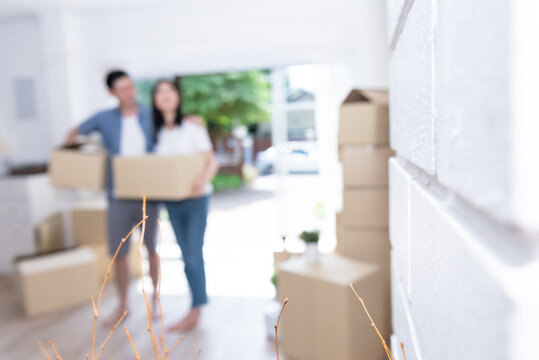 Blur images of couple, husband and  wife helping each other to lift the box Happily, to move into a new home For starting a marriage and family life.