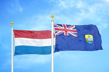 Netherlands and Saint Helena two flags on flagpoles and blue sky