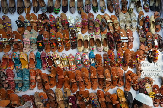 Traditional mojari shoes (Juttis) of various designs on display. These are shoes made from leather and decorated with various elements for royalty. Indian Traditional Shoes.
