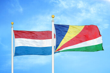 Fototapeta na wymiar Netherlands and Seychelles two flags on flagpoles and blue sky