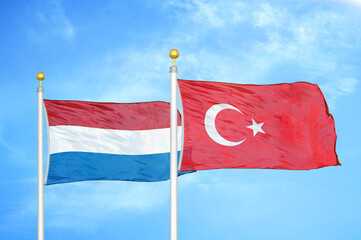 Netherlands and Turkey two flags on flagpoles and blue sky