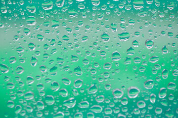 Water drops on the glass with a colored turquoise background. Drop of water.