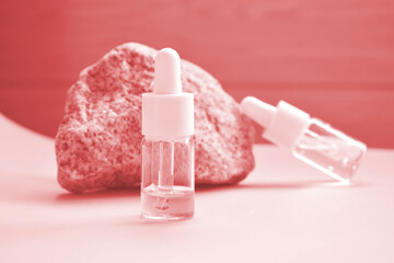 Cosmetic oil in a bottle with a pipette for the face and body on a natural background with a decor in the form of a natural stone. Space for text.