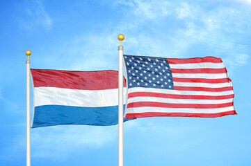 Netherlands and United States two flags on flagpoles and blue sky
