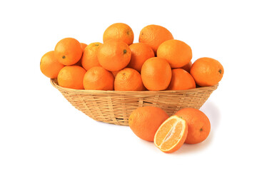 Oranges in a big wicker basket with whole oranges and a halfisolated on white