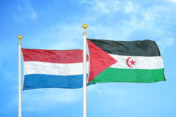 Netherlands and Western Sahara two flags on flagpoles and blue sky