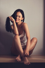 Beautiful smiling woman with eyes closed She is in pajamas. She looks beautiful and sexy. vertical