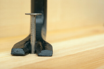 one iron nail and scrap in a wooden board