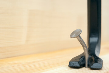 one curve iron nail and scrap in a wooden board