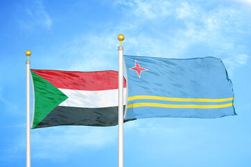 Sudan and Aruba two flags on flagpoles and blue sky