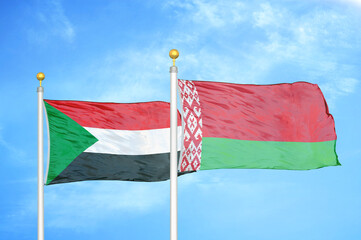 Sudan and Belarus two flags on flagpoles and blue sky