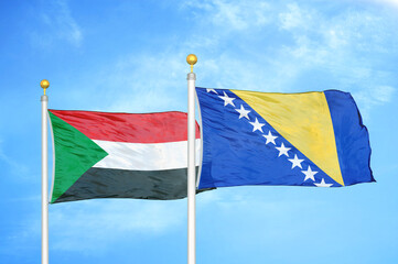 Sudan and Bosnia and Herzegovina two flags on flagpoles and blue sky