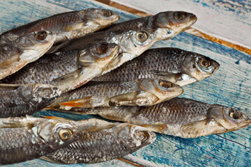 Stewed river fish lying in a basket on a dark background. Traditional beer snack.