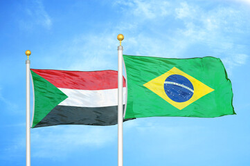 Sudan and Brazil two flags on flagpoles and blue sky