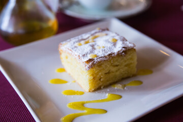 appetizing slice of almond cake on square white plate