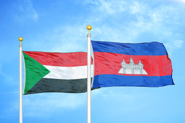 Sudan and Cambodia two flags on flagpoles and blue sky