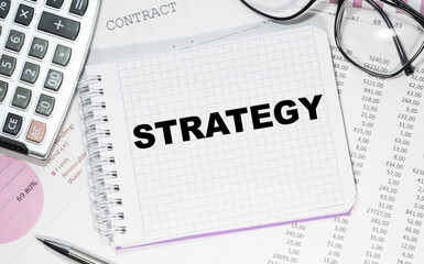 Business concept - workspace office desk and notebook with writing SRTATEGY