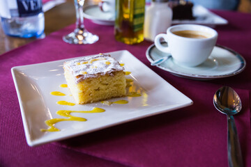 appetizing slice of almond cake on square white plate