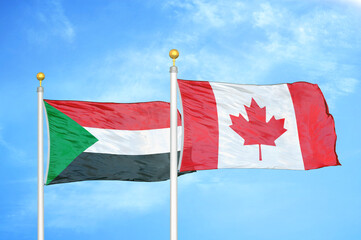 Sudan and Canada two flags on flagpoles and blue sky