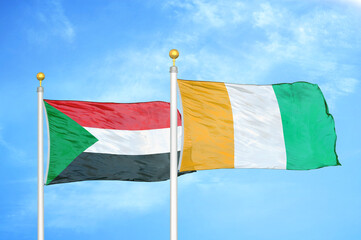 Sudan and Cote d'Ivoire Ivory coast two flags on flagpoles and blue sky