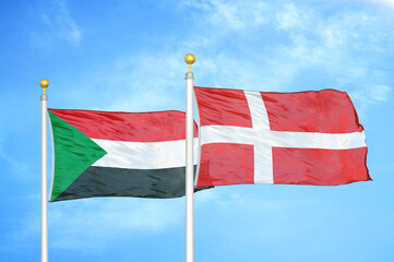 Sudan and Denmark two flags on flagpoles and blue sky