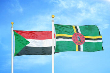 Sudan and Dominica two flags on flagpoles and blue sky