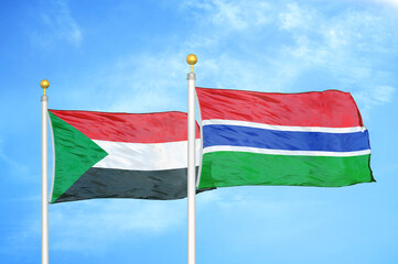 Sudan and Gambia two flags on flagpoles and blue sky