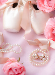 Ballerina pointe shoes are classic ballet shoes with pearl decorations and roses on pink fabric. Ballet shoes selective focus. © Victor