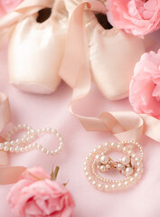 Ballerina pointe shoes are classic ballet shoes with pearl decorations and roses on pink fabric. Ballet shoes selective focus.