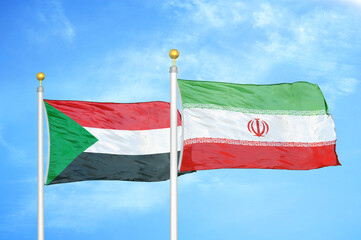Sudan and Iran two flags on flagpoles and blue sky