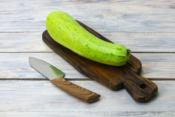 Zucchini on dark cutting board and knife. The concept of environmentally friendly products, mono-diet