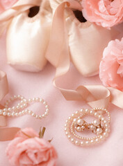 Ballerina pointe shoes are classic ballet shoes with pearl decorations and roses on pink fabric. Ballet shoes selective focus. © Victor