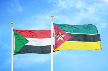 Sudan and Mozambique two flags on flagpoles and blue sky
